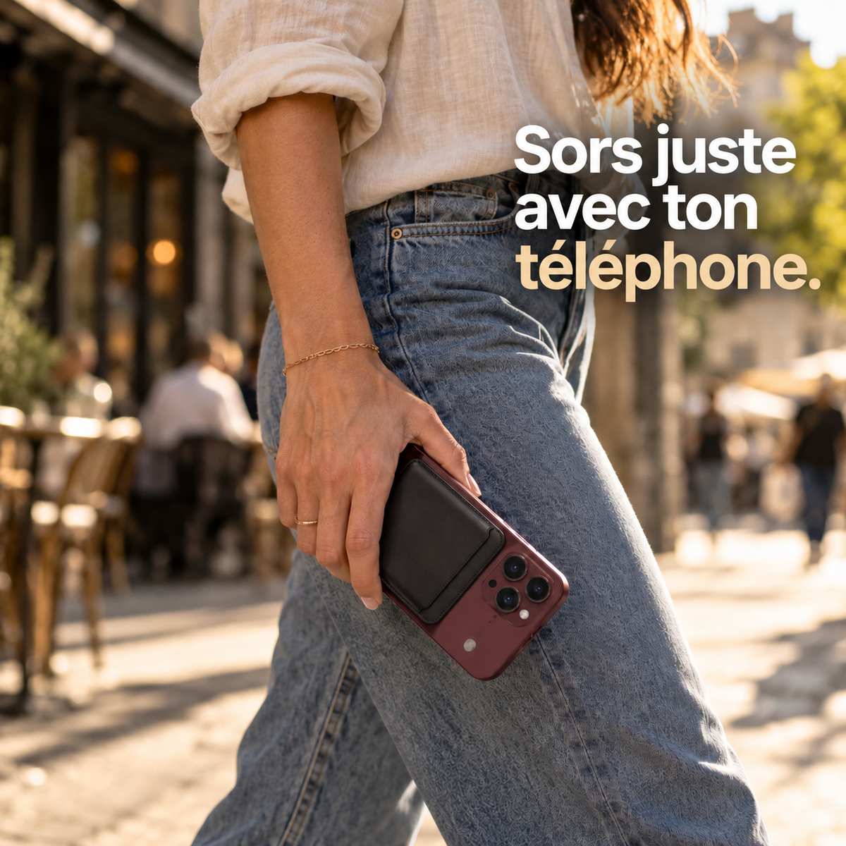 Jeune femme marchant dans une rue ensoleillée, smartphone à la main avec un porte-cartes noir fixé au dos. Texte : « Sors juste avec ton téléphone. »